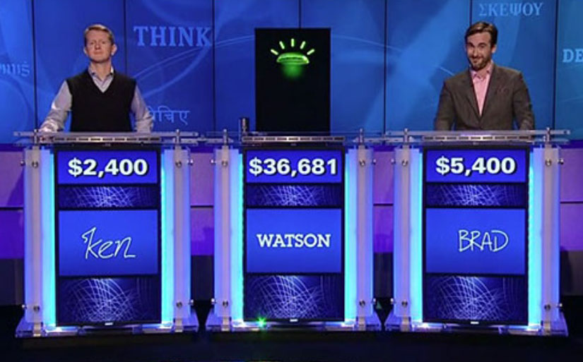 Image of Jeopardy set with two human contestants flanking "Watson"