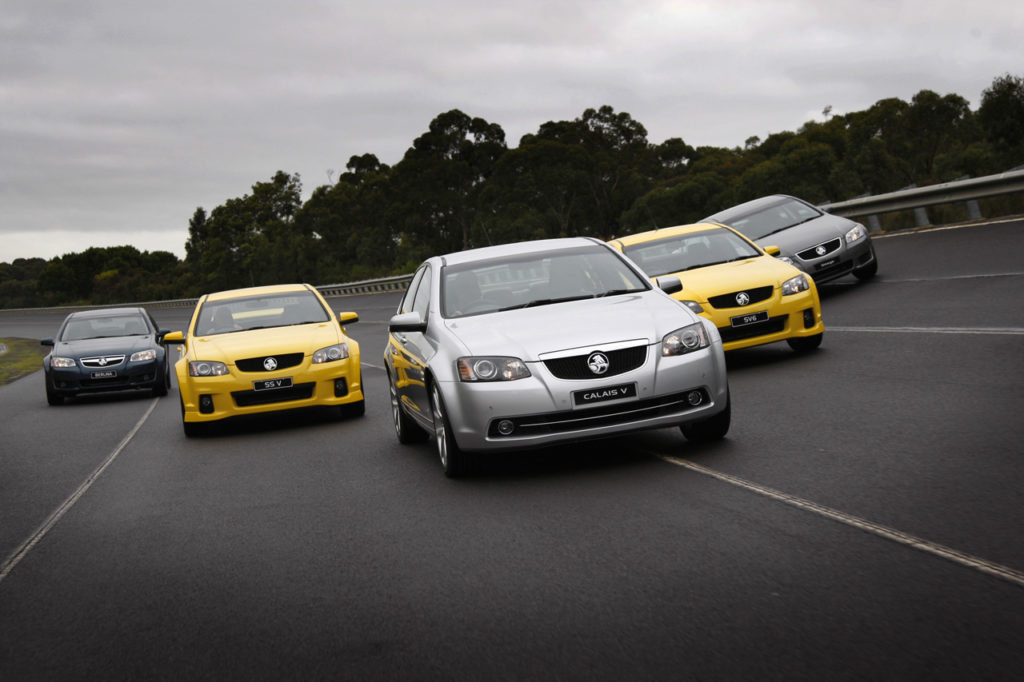 Five new autos on highway in flying V formation